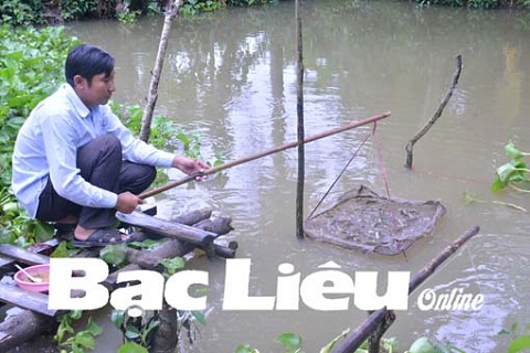 Anh Lê Văn Chuyện cho cá ăn.